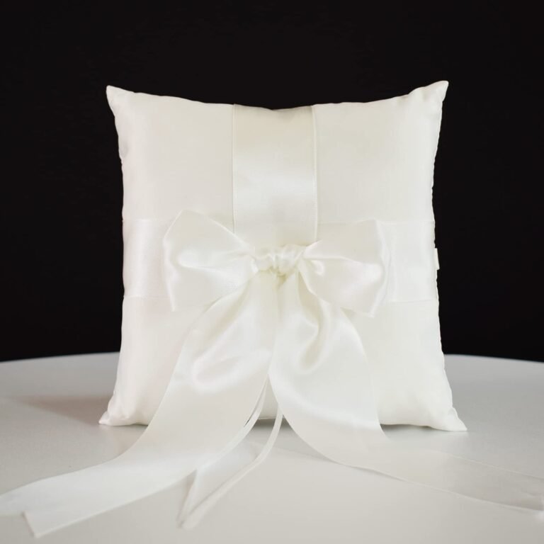 White satin ring pillow with a large bow and ribbons