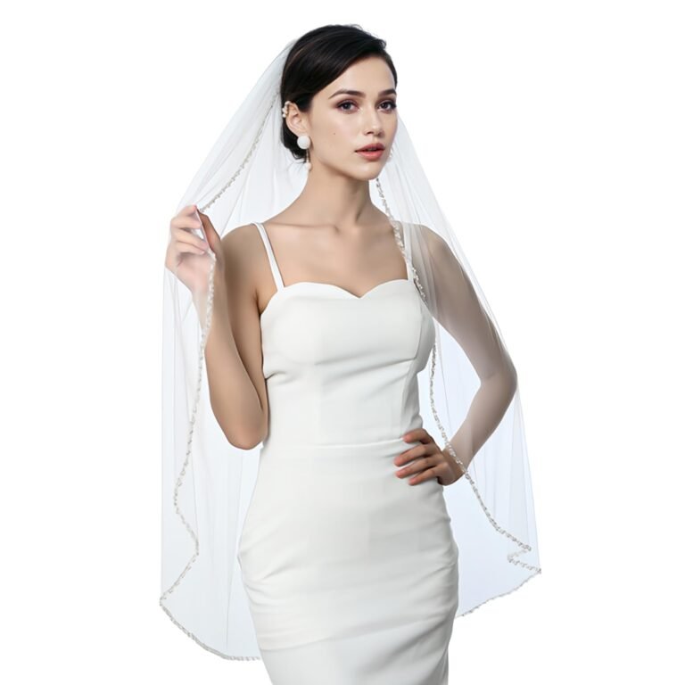 Bride in white dress and veil with beaded trim, posing for the camera