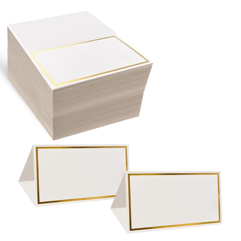 Stack of white place cards with gold borders, two folded