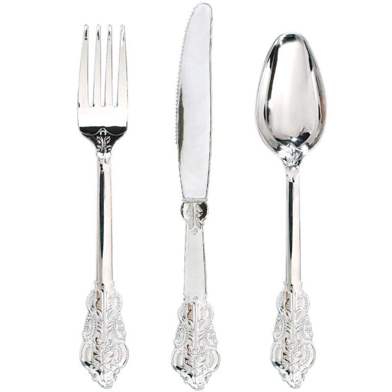 Silver plastic fork, knife, and spoon set with ornate handles on white background